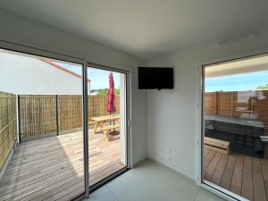 a room with a balcony with a flat screen tv at Maisons Phoenix in Saint-Jean-de-Monts