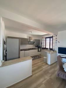 a large kitchen with white appliances and a table at Attico con vista mozzafiato a due passi dal mare in Terrasini +20 photos