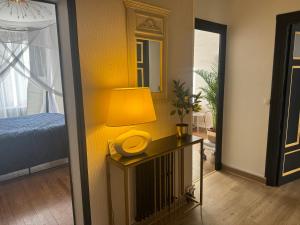 une pièce avec une lampe sur une table avec un lit dans l'établissement L'Experience Appartement & SPA Privé CHAMBERY, à Chambéry