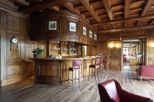 a bar in a room with wooden walls and chairs at Lodge Golf Villa d'Este in Montorfano