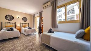 a hotel room with two beds and a window at Hostal Dinamarca in San Antonio