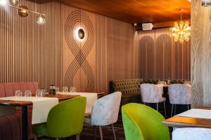 a restaurant with tables and chairs and a chandelier at Complex Turistic Creanga Resort & Spa in Târgu Ocna +103 photos