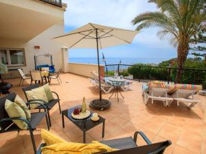 eine Terrasse mit Stühlen, Sonnenschirm und Tisch in der Unterkunft Apartment Belle Vue by Interhome in Almuñécar