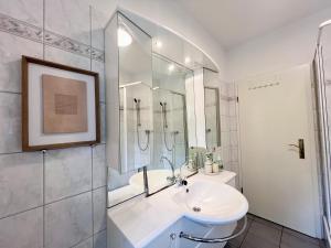 ein weißes Badezimmer mit Waschbecken und Dusche in der Unterkunft gina stay - Apartmenthaus im Zentrum von Quedlinburg in Quedlinburg