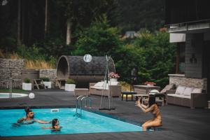dwie kobiety bawiące się w basenie w obiekcie Czarny Kamień Resort & SPA w Szklarskiej Porębie