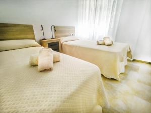 a bedroom with two beds with white sheets at Banana Beach in Marbella