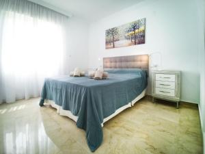 a bedroom with a bed with a blue blanket at Banana Beach in Marbella