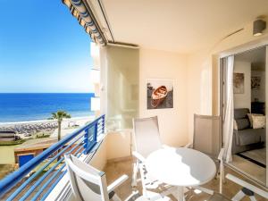uma varanda com uma mesa e cadeiras e o oceano em Banana Beach em Marbella