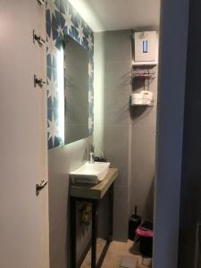 Duplex guest house in Batroun في البترون: حمام مع حوض ومرآة