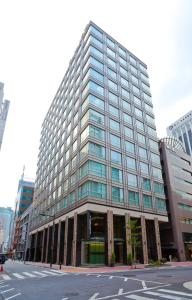 a tall building with glass windows in a city at Solaria Nishitetsu Hotel Ginza in Tokyo