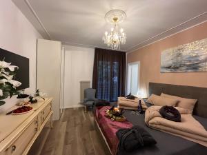 a living room with a bed and a chandelier at Guesthouse Le Palme in Postal