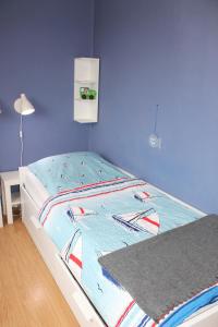 a bed in a bedroom with a blue wall at Landhaus Lippmann Whg6 in Grönwohldshorst