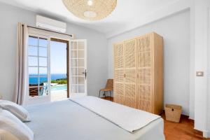 a bedroom with a bed and a view of the ocean at Villa La Louisière - Les Issambres in Saint-Peïre-sur-Mer +20 photos