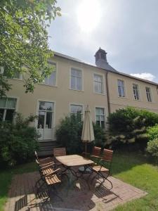 a table with an umbrella in front of a building at An der Aue in Klütz