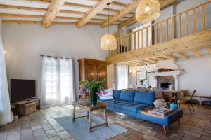 a living room with a blue couch and a tv at Villa La Louisière - Les Issambres in Saint-Peïre-sur-Mer