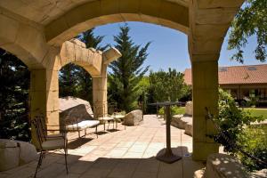 a patio with an archway with chairs and a table at Don Carlos in Huarte