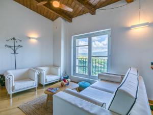a living room with white furniture and a large window at Apartment Casa del Sole by Interhome in Castelnuovo dellʼAbate