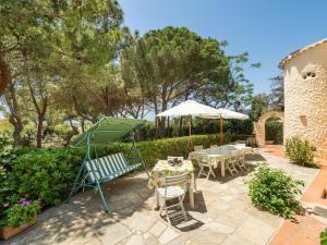 a patio with a table and chairs and an umbrella at Villa La Casetta del Mare by Interhome in Villasimius