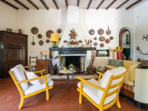 a living room with two chairs and a fireplace at Villa La Casetta del Mare by Interhome in Villasimius +49 photos