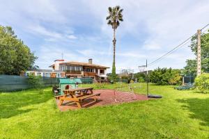 un parque con mesa de picnic y parque infantil en Family House Gijón en Gijón