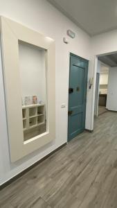 ein leeres Zimmer mit blauer Tür und Holzböden in der Unterkunft Cal Feliu Piso amplio en el centro de Reus in Reus