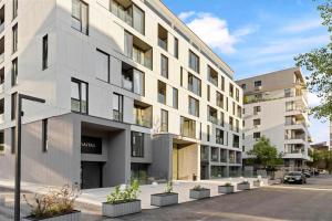 an apartment building with a parking lot in front of it at Harmony Property WIN HERASTRAU in Bucharest