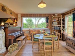 una sala da pranzo con tavolo e pianoforte di Holiday Home Wood love Home by Interhome a Plerneuf