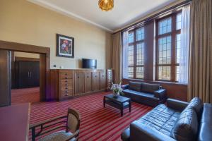 a living room with a couch and a tv at Grand Hotel Amrâth Amsterdam in Amsterdam