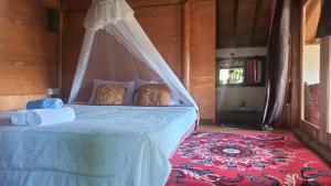 a bedroom with a bed with a mosquito net at Bunga Maliq Bungalow Lombok in Tetebatu