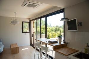 Una cocina con una mesa y sillas en una habitación. en La maison de Brigitte, en LʼIsle-sur-la-Sorgue