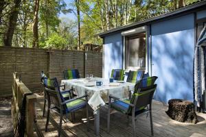 una mesa y sillas en la cubierta de una casa pequeña en Bungalow Hörselberg, Bgl 15, en Dranske