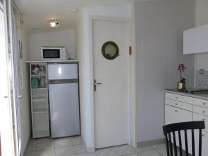 a kitchen with a white refrigerator and a microwave at Holiday Home Roses Tremières by Interhome in Talmont +13 photos