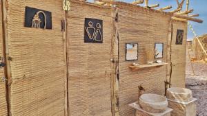 a wooden building with a toilet and signs on it at Gabila Blue Lagoon in Dahab