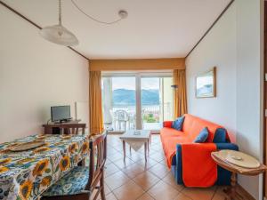 een slaapkamer met een bed, een stoel en een raam bij Apartment Euroville-4 by Interhome in Germignaga