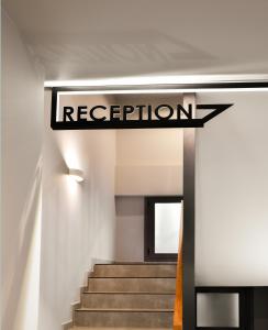 a sign for the reception of a building with stairs at CORYLUS Luxury Rooms & Suites in Leptokaria