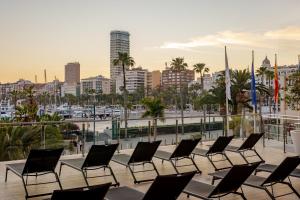 a row of chairs on a balcony with a city at Melia Alicante in Alicante