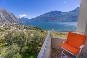 a chair on a balcony with a view of a lake at Hotel Villa Margherita in Limone sul Garda