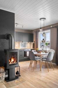 a living room with a fireplace and a table with chairs at Voss Resort Bavallstunet in Skulestadmo