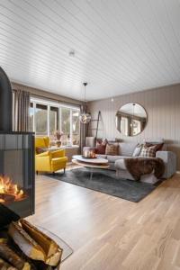 sala de estar con sofá y chimenea en Voss Resort Bavallstunet en Skulestadmo