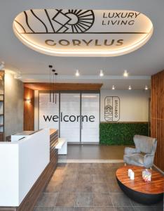 - un hall avec une chaise et un panneau de bienvenue dans l'établissement CORYLUS Luxury Rooms & Suites, à Leptokaryá