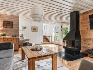 ein Wohnzimmer mit einem Kamin und einer Holzdecke in der Unterkunft Chalet Kvarnfallet by Interhome in Ullared