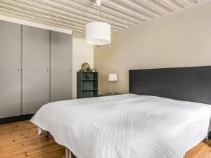 Schlafzimmer mit einem großen weißen Bett und einem schwarzen Kopfteil in der Unterkunft Chalet Kvarnfallet by Interhome in Ullared