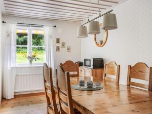 eine Küche und ein Esszimmer mit einem Holztisch und Stühlen in der Unterkunft Chalet Kvarnfallet by Interhome in Ullared