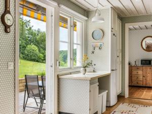 eine Küche mit einem Waschbecken, einem Fenster und einem Tisch in der Unterkunft Chalet Kvarnfallet by Interhome in Ullared + 18 Fotos