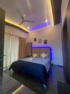 a bedroom with a large bed with blue lights at Sweet Water Villa in Panchgani
