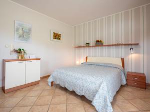a bedroom with a bed and a dresser at Holiday Home Collina San Ponzio by Interhome in Barolo