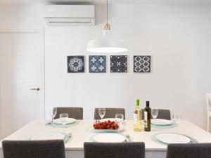 a white dining room with a table with chairs and wine glasses at Apartment La Najarra by Interhome in Almuñécar +31 photos
