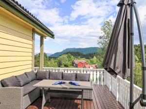 a patio with a couch and an umbrella on a deck at Holiday Home Gule huset by Interhome in Bruntveit