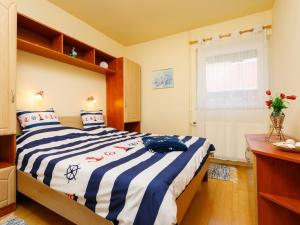 ein Schlafzimmer mit einem Bett mit einer blau-weißen gestreiften Decke in der Unterkunft Holiday Home Toth - BAC109 by Interhome in Badacsony