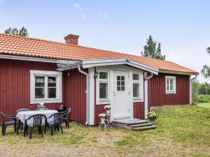 a red house with a table and chairs in front of it at Chalet Motorp by Interhome in Arboga